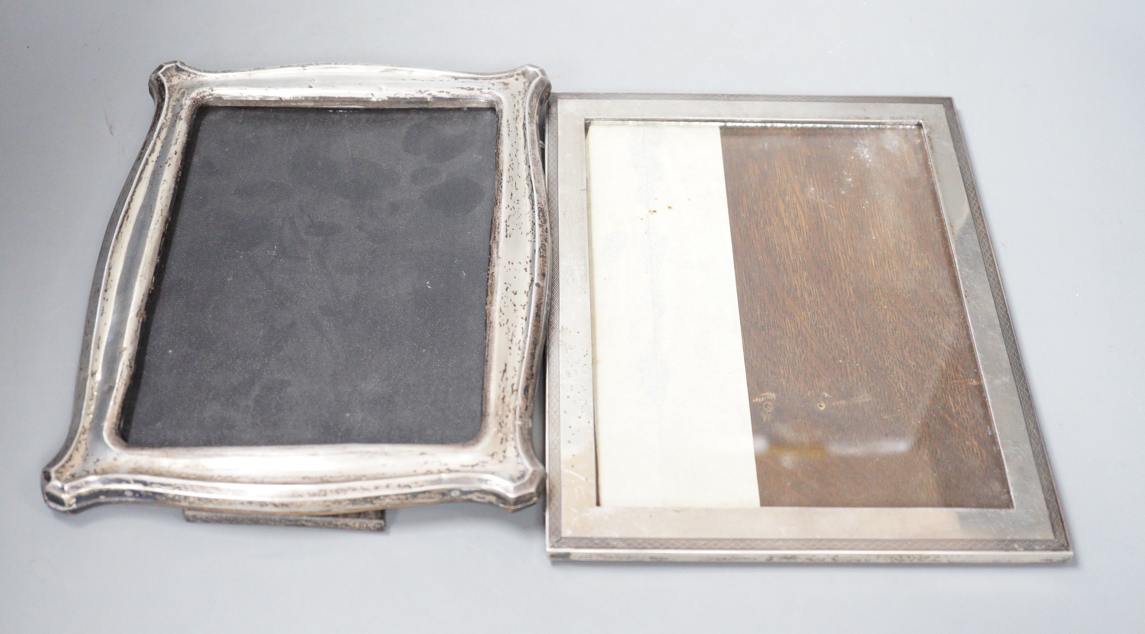 A George V silver mounted rectangular photograph frame, Chester 1922, 23.6cm and a shaped rectangular silver mounted photograph frame, Birmingham, 1912.